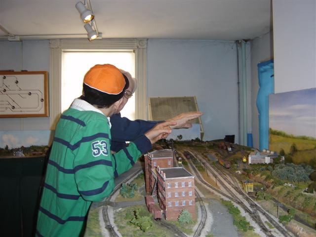 Chuck Bindig discusses the model railroad room with a young boy.